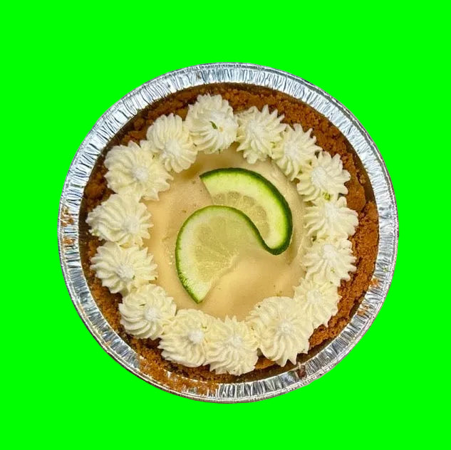 small key lime pie with a lime slice in the middle on an orange background